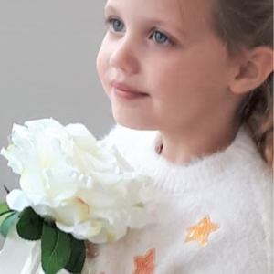 Image of flowergirl holding large cream rose