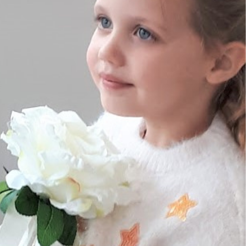 Image of flowergirl holding large cream rose