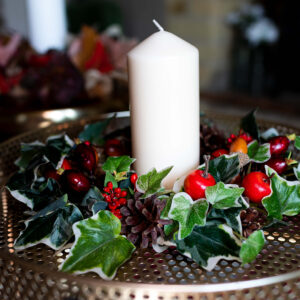 Image of table centre with faux berries and variegated ivy