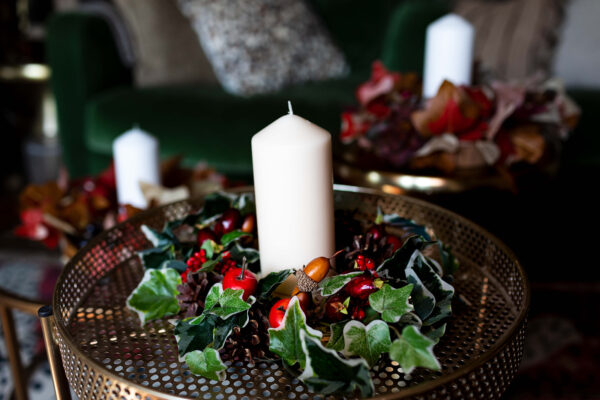 Image of table centre with faux berries, pinecones and variegated ivy