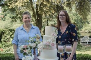 Photo of wedding cake and two lady cake designers