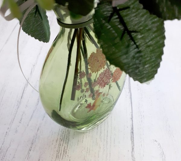 Close up image of a bud vase painted with flowers and a little bird