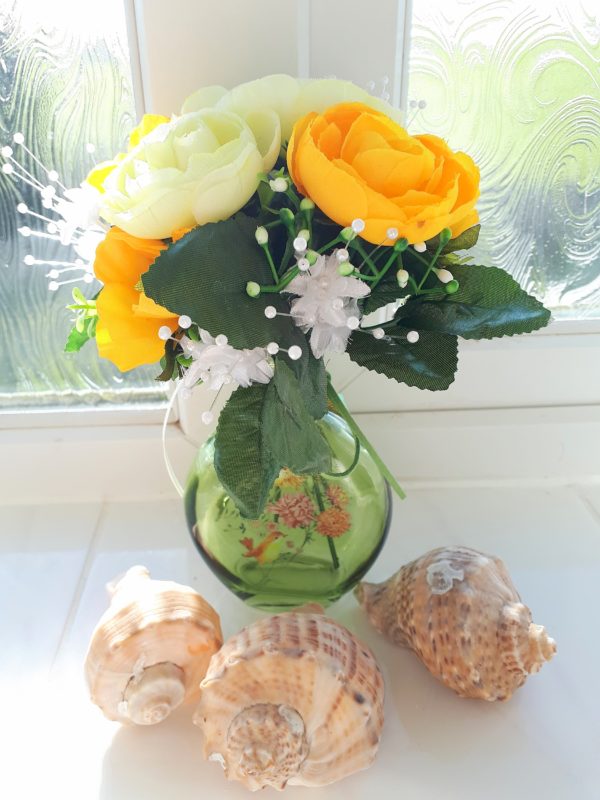 Image of small glass vase with yellow and white spring flowers