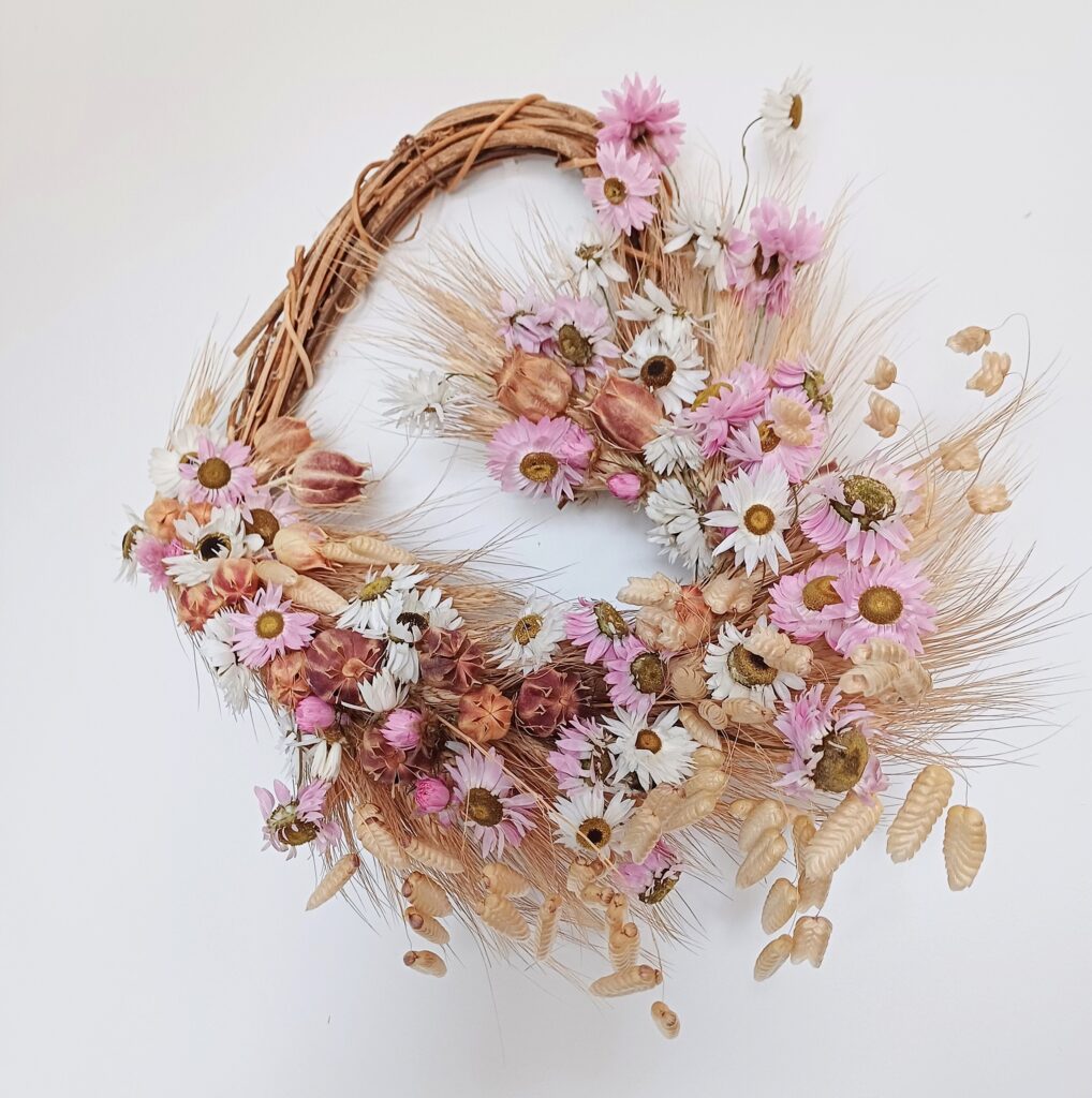 Heart shaped wreath with dried grasses and pink and white dried flowers