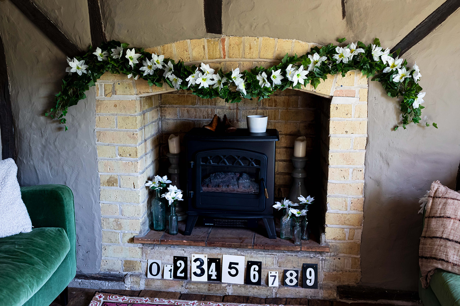 Image of cottage stone fireplace with silk ivy garland and white silk poinsettias