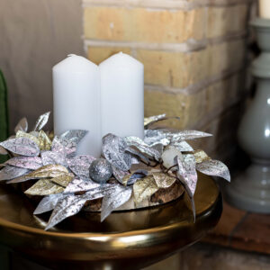 silver and gold leaves on a woodslice create a festive table centre