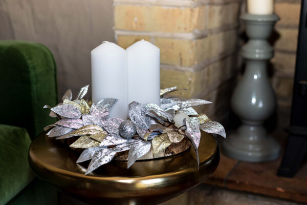 silver and gold leaves on a woodslice create a festive table centre