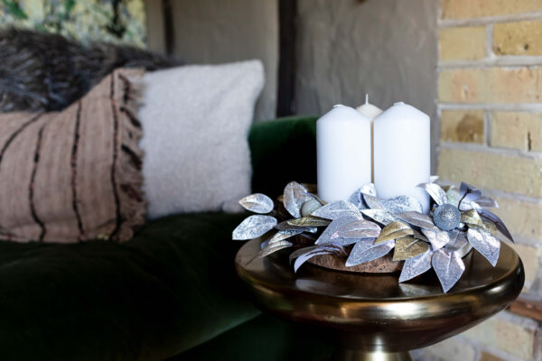 silver and gold leaves on a woodslice create a festive table centre