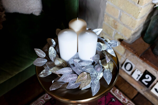 silver and gold leaves on a woodslice create a festive table centre