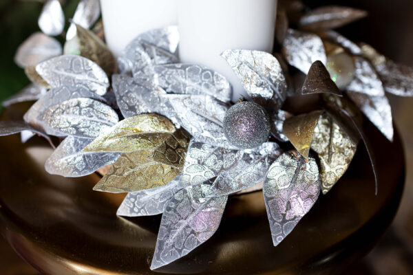 silver and gold leaves on a woodslice create a festive table centre