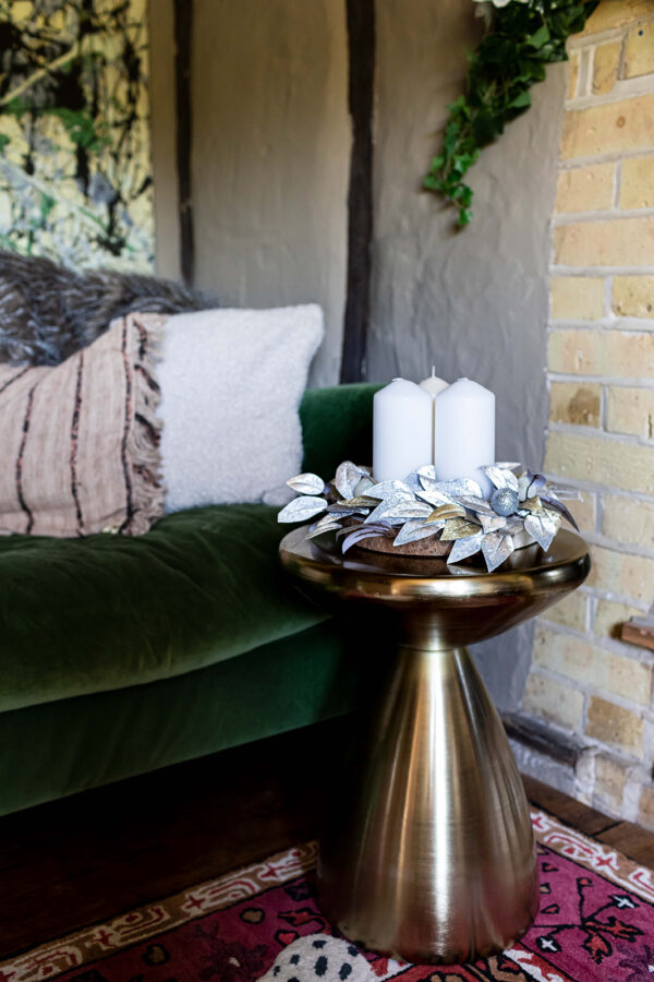 silver and gold leaves on a woodslice create a festive table centre