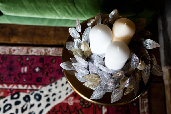 silver and gold leaves on a woodslice create a festive table centre