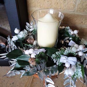 Silver and white decorations on a wooden base for a festive table centre