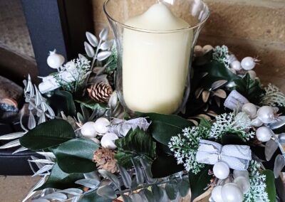 Silver and white decorations on a wooden base for a festive table centre