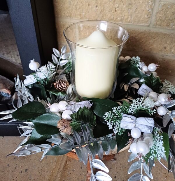 Silver and white decorations on a wooden base for a festive table centre