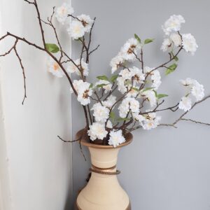Vase of white cherry blossom branches