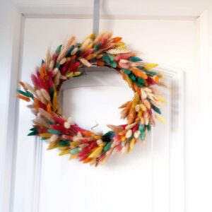 Image of a summer wreath made of dried grasses, dyed in many colours