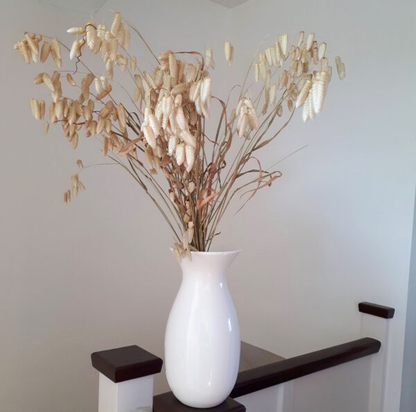 Image of quaking grasses in a white vase