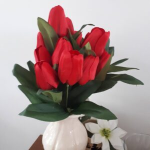 Red tulips in a tall white vase