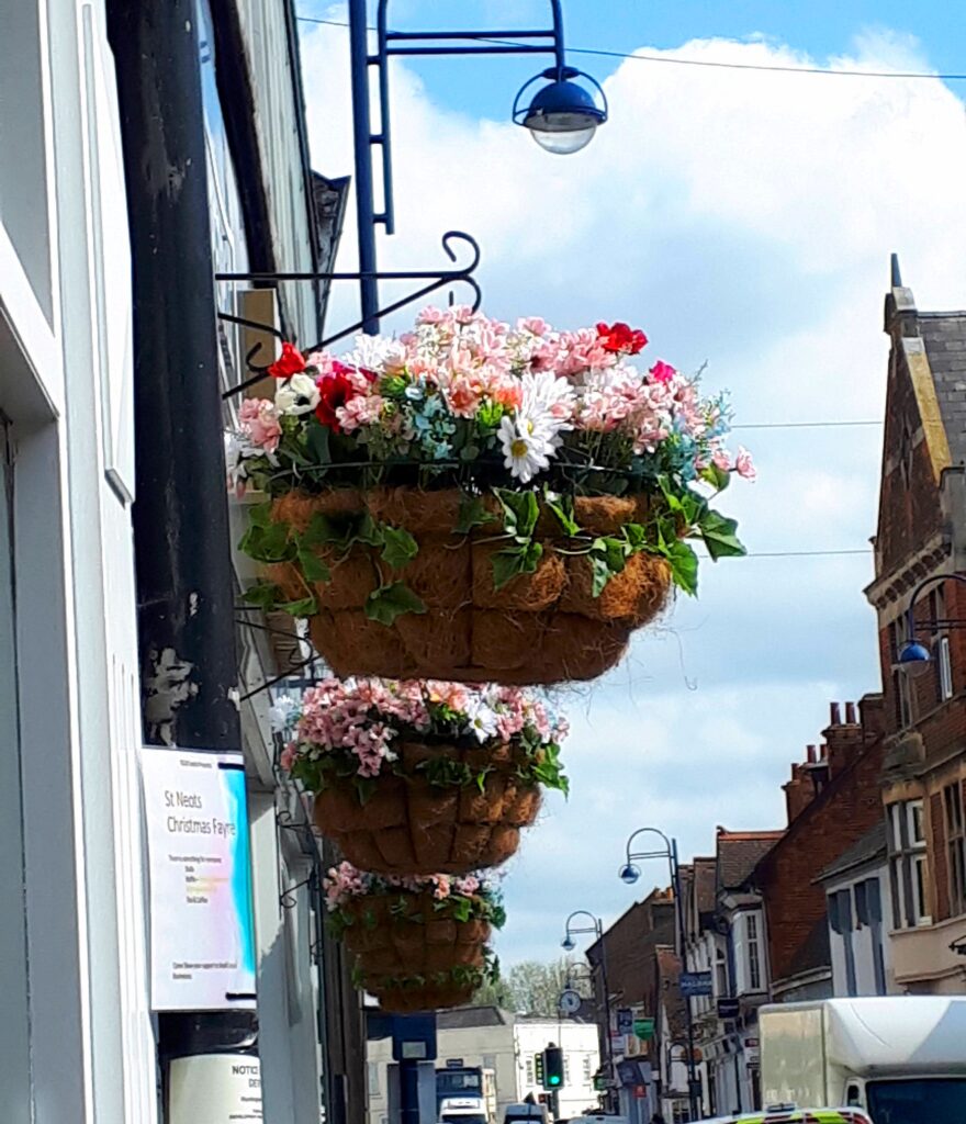 Image of colourful hanging baskets outside Esquires Coffee Shop