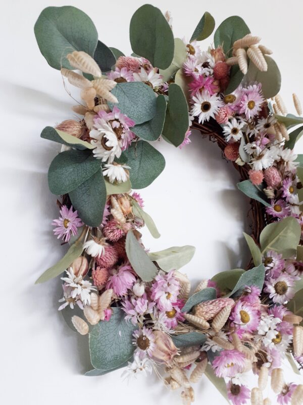 Image of a wreath made with pink and white everlasting dried flowers, natural quaking grasses, and faux dollar eucalyptus