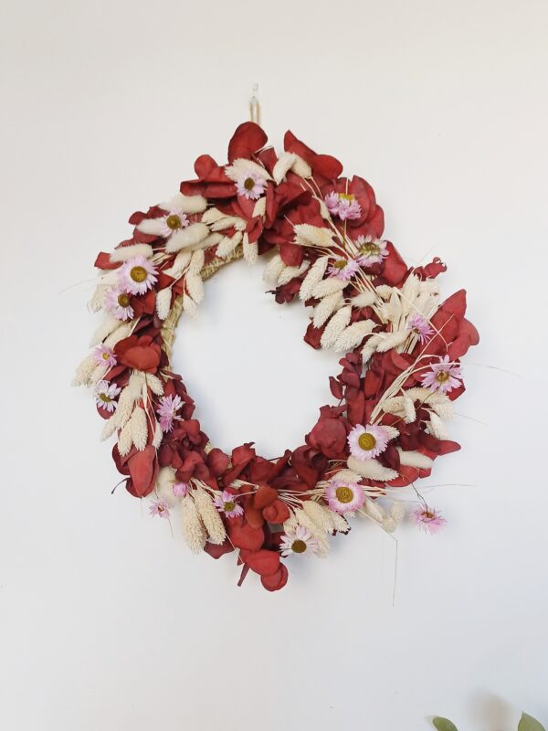 Red eucalyptus wreath with dainty pink dried flowers and bleached grasses