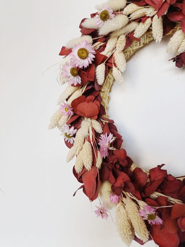 Red eucalyptus wreath with dainty pink dried flowers and bleached grasses