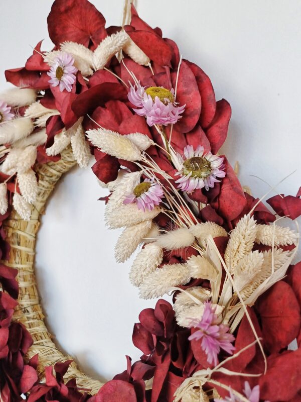 Red eucalyptus wreath with dainty pink dried flowers and bleached grasses