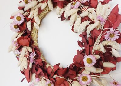 Red eucalyptus wreath with dainty pink dried flowers and bleached grasses