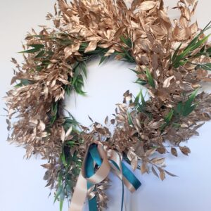 Image of a bright gold ruscus luxury festive wreath with green accents