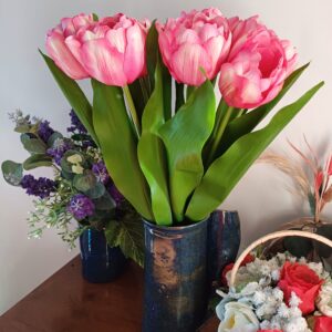 Pink variegated tulips in a dark blue ceramic vase