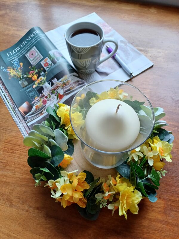 Image of spring flower table centre, with a magazine and cup of coffee.