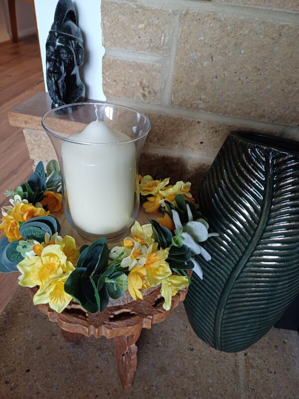 Image of spring flower table centre, showing yellow daffodils and jonquils, next to a leaf ceramic vase