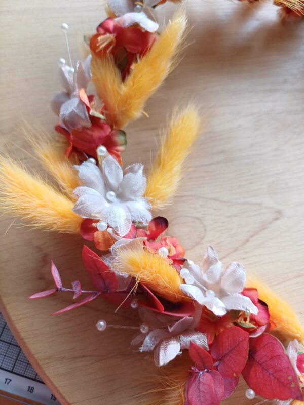 Floral crown detail showing deep orange flowers, champagne babies breath and orange bunnytail grasses