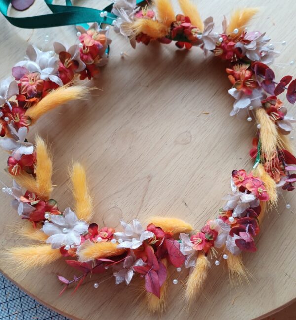 Flowergirl floral crown with deep orange flowers, champagne babies brerath flowers, and orange bunnytail grasses