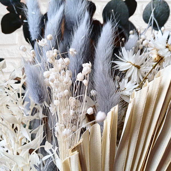 Close up photo of dyed grey bunny tail grasses and cream dried flowers