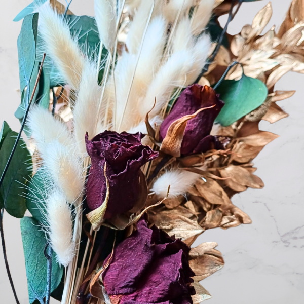 Image of deep red dried roses, and green and gold preserved foliage