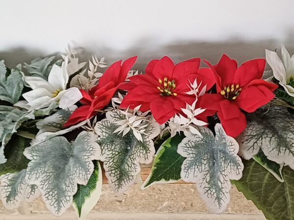 Red and white silk poinsettias, arranged with silver and green faux foliage, for a mantel piece decoration