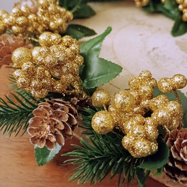 Close up of the Table centre decorated with sparkly gold berries and natural mini pinecones