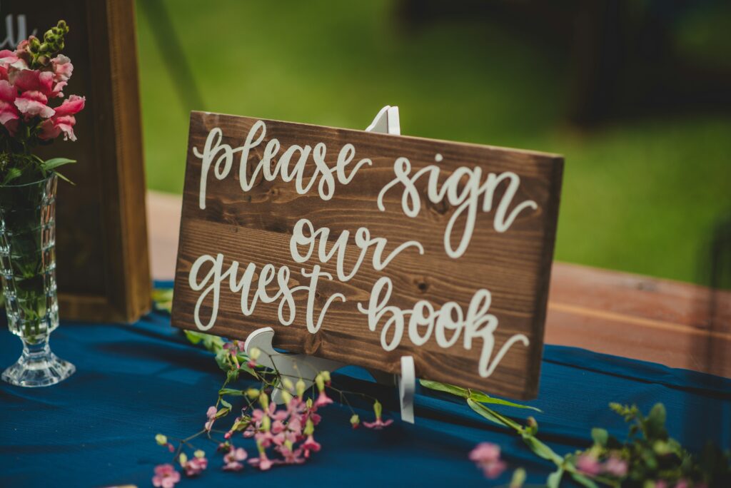 Wooden sign saying Please sign our guest book
