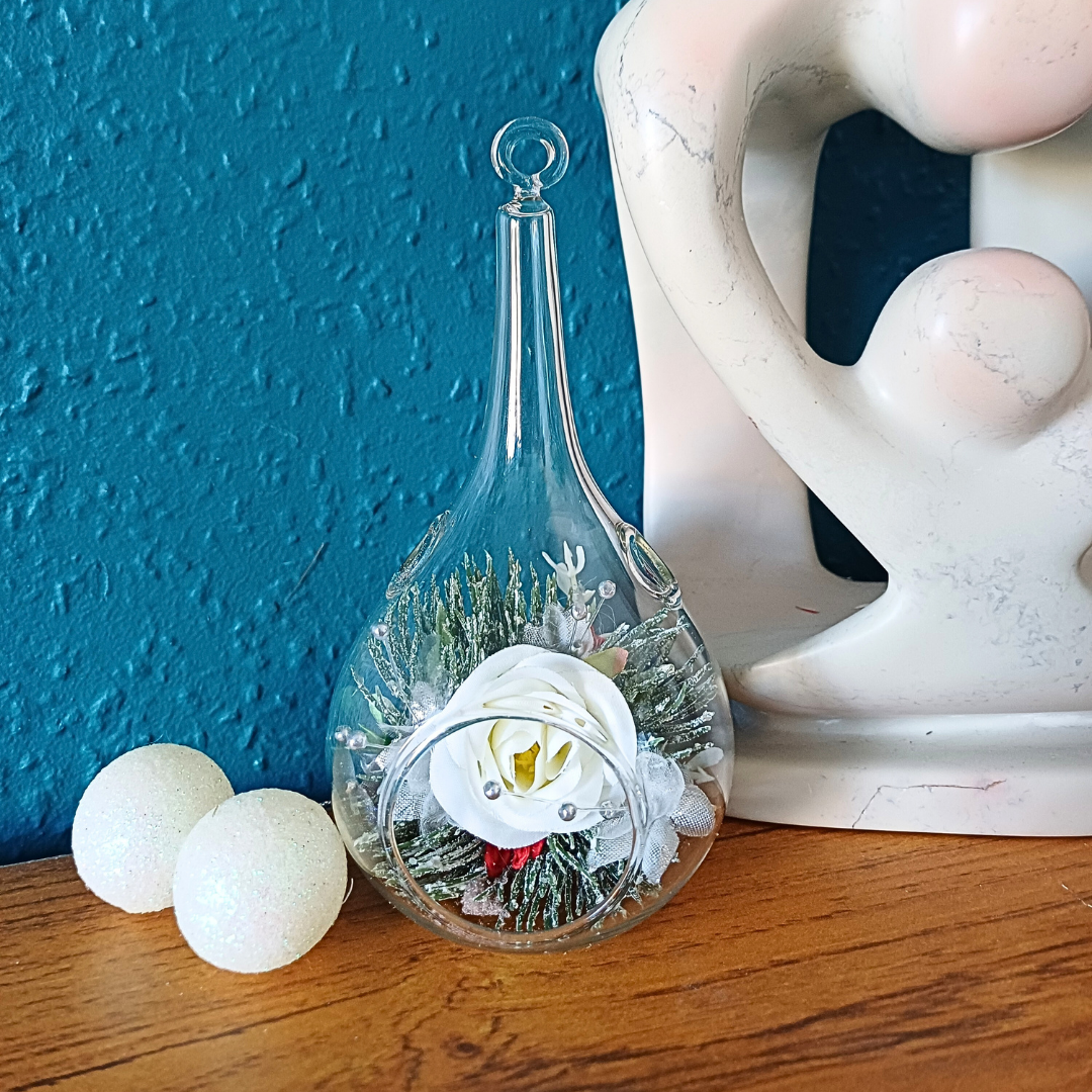 Glass teardrop festive ornament with white silk rose and silver faux pines foliage