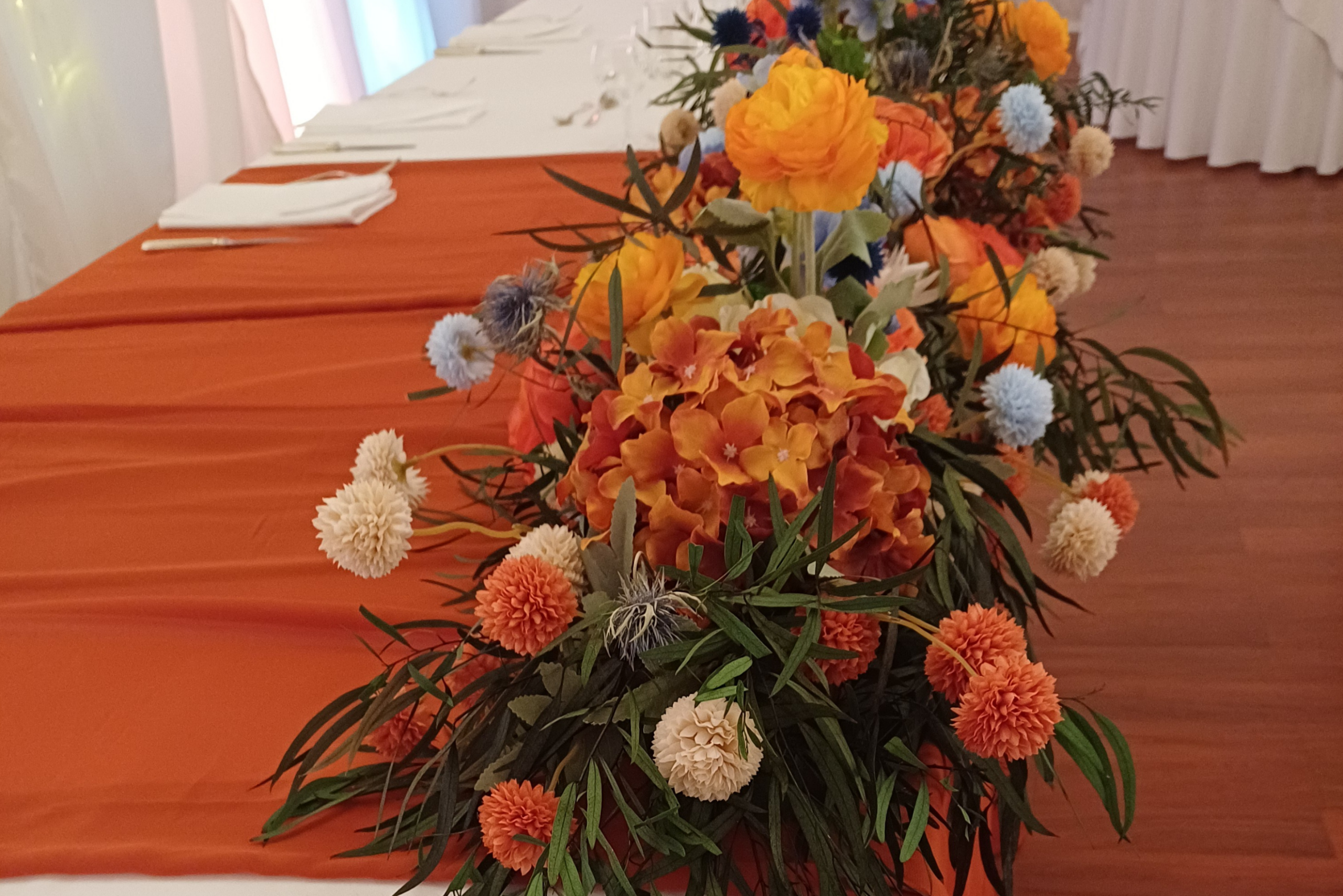 Image showing table centre with bright orange flowers with pale blue flowers