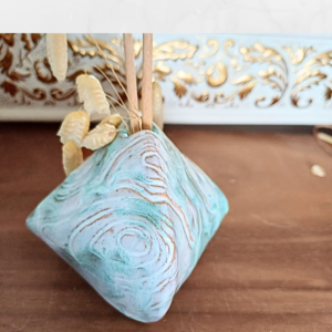 Image of triangular bud vase with swirly patterns, colours pale blue and turquoise