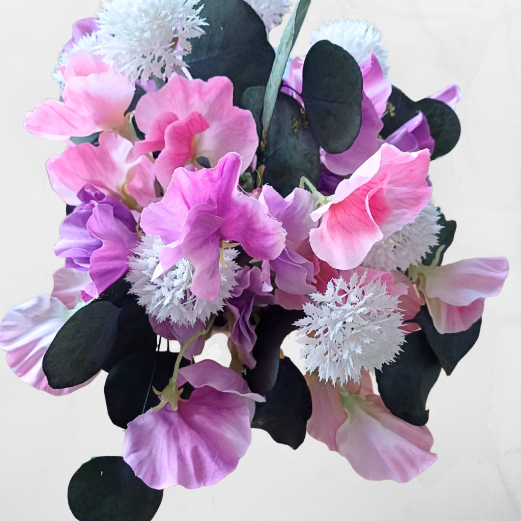 Image of sweetpeas in pink and mauve, with white pompom flowers and dark gren foliage