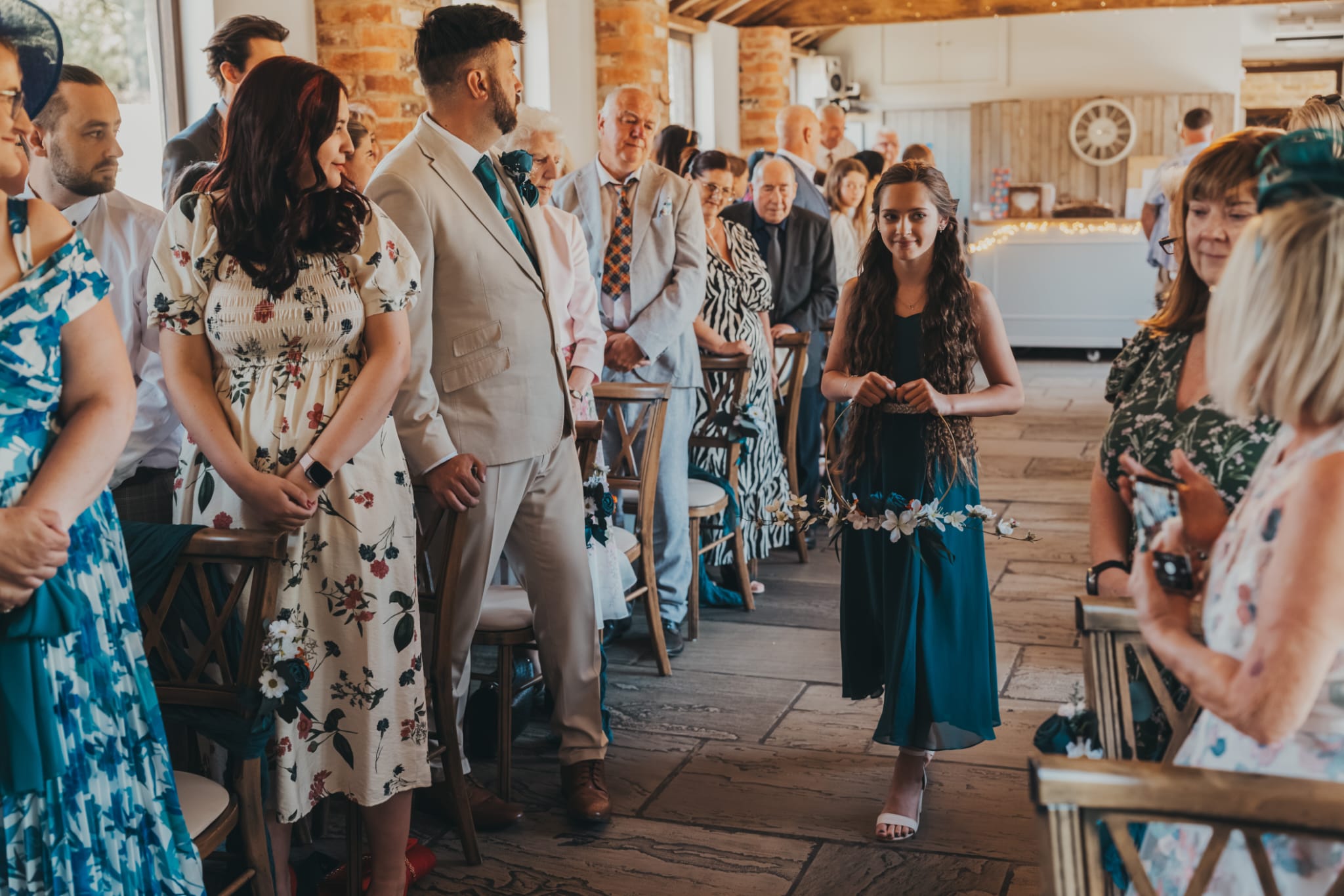 Flowergirl walking downthe aisle carrying hoop of flowers